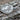 Side profile of polished sterling silver signet ring band displayed on textured bark surface