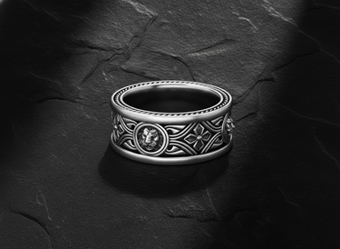 925 sterling silver lion ring with Celtic knotwork and quatrefoil patterns on dark slate background