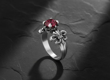 Front view of 925 silver fleur-de-lis ring showing decorative shoulder details and faceted ruby centerstone