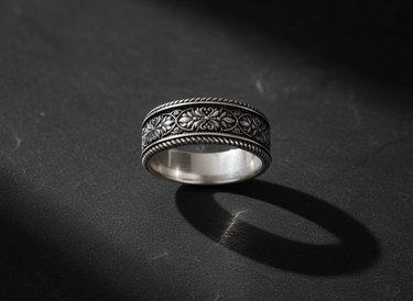 Close-up of ornate silver filigree ring with oxidized finish highlighting delicate floral pattern details