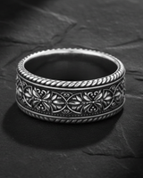 925 sterling silver filigree ring with intricate floral scrollwork displayed on textured slate background