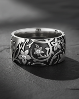 925 sterling silver floral ring with intricate botanical pattern and gemstone accents on dark slate background