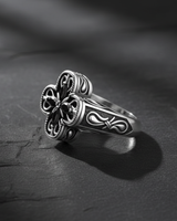 Close-up of handcrafted silver cross ring displaying intricate metalwork and oxidized finish details