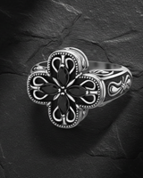 Side angle view of ornate cross ring showing detailed scrollwork band and beaded edges with gemstone setting
