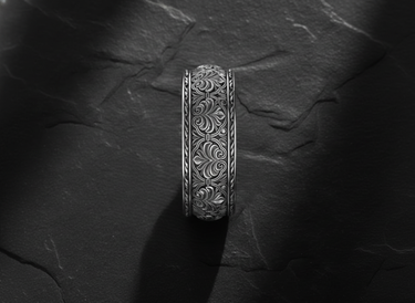 Side profile view of ornate floral ring showing detailed botanical engravings and wide band craftsmanship