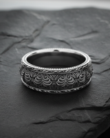 925 sterling silver floral ring with raised scrollwork and leaf border patterns displayed on dark slate surface