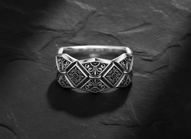 925 sterling silver geometric ring with diamond and square patterns displayed on textured slate background