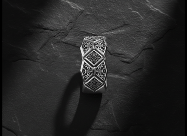 Side profile view of handcrafted geometric ring showing detailed floral motifs and oxidized silver finish