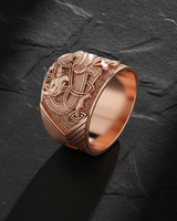 Rose gold celtic griffin ring with oxidized detailing and mythical creature design on black slate backdrop