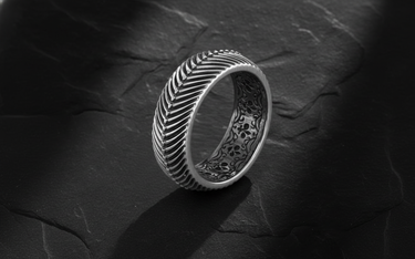 Side angle view of wide band herringbone ring showing geometric texture and filigree interior detail