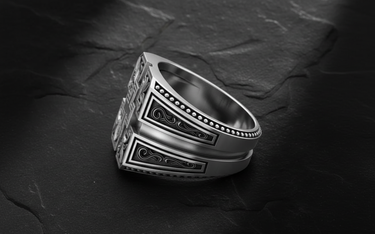 Close-up of ornate cross signet ring displaying intricate engraving and oxidized sterling silver finish