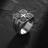 925 sterling silver cross signet ring with ornate fleur-de-lis motifs displayed on textured slate background