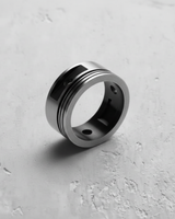 Angled view of handcrafted silver mechanic ring showing wrist pin holes and industrial groove aesthetic
