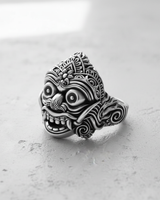 Side profile of the handcrafted silver Balinese demon mask ring, highlighting the depth of the carving and band design.