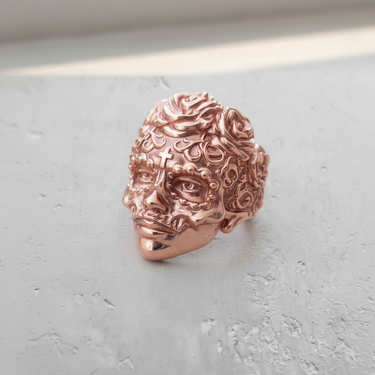 A rose-gold finish on the Silver Sugar Skull Ring, angled to display the detailed rose carvings in the hair and side profile.