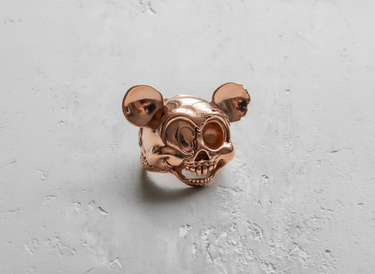 Rose gold vermeil cartoon mouse skull ring with a high-polish finish, capturing the light on its round ears and skull.