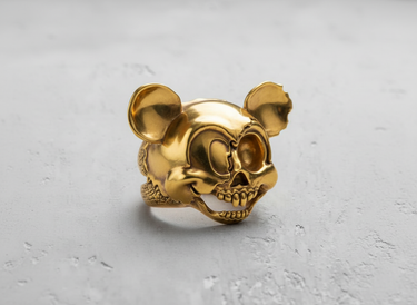 14K gold vermeil mouse skull ring with a split-face design, showcasing the cartoon and skull halves on a textured surface.