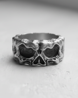 Front view of a rugged silver skull ring, showcasing the deep eye sockets and textured 925 sterling silver band.