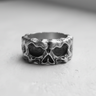 Front view of a rugged silver skull ring, showcasing the deep eye sockets and textured 925 sterling silver band.