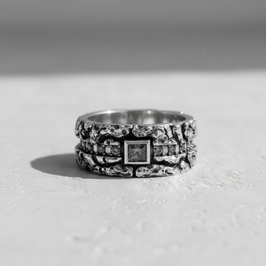 Textured silver gemstone ring shown from the front, highlighting the central square gem and rugged band texture.