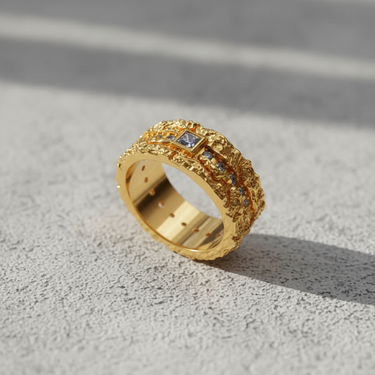 14K gold vermeil textured gemstone ring with a central blue square gem, shown at an angle on a concrete surface.