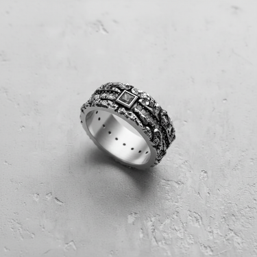 Handcrafted textured silver gemstone ring at an angle, displaying the oxidized finish that enhances its organic design.