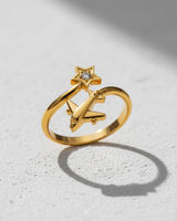 Gold vermeil silver airplane star ring with a brilliant central gemstone, showcasing its adjustable open band design on a white surface.