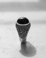 Front view of the handcrafted silver basketweave cabochon ring, detailing the wide, textured band and central black stone setting.