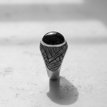 Front view of the handcrafted silver basketweave cabochon ring, detailing the wide, textured band and central black stone setting.