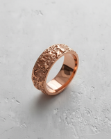 Rose gold plated textured silver ring with a wide band and intricate organic, coral-like pattern on a light background.