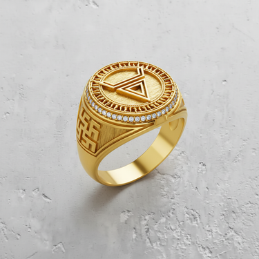 Gold vermeil geometric signet ring with an inverted triangle symbol and sunburst border, shown on a textured surface.