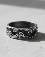 Oxidized Silver Wave Grid Ring with high-contrast baroque wave details, displayed in direct sunlight on a textured background.