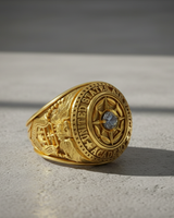 Silver Air Force Academy ring with a blue gemstone, showing the detailed eagle emblem on the side, on a concrete surface.