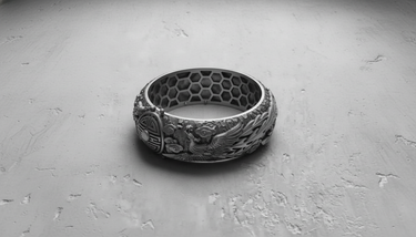 Top-down view of the silver Dragon Phoenix Ring highlighting the inner honeycomb pattern and the sculpted phoenix relief work.