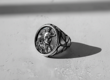 Sterling silver mythology ring for men, angled view showing the oxidized finish on the detailed warrior cameo and patterned band.