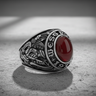 Silver West Point ring with oxidized details, showcasing the US Military Academy crest and red stone on a textured surface.