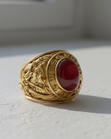 Close-up detail shot of the handcrafted engravings on the shank of a collegiate-style sterling silver class ring in natural light.