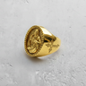 Gold vermeil Jesus signet ring featuring Sacred Heart relief and fluted bezel on textured white background