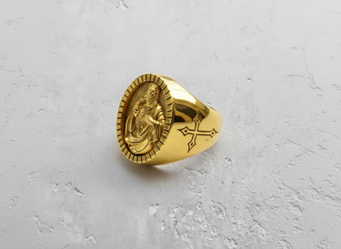 Gold vermeil Jesus signet ring featuring Sacred Heart relief and fluted bezel on textured white background