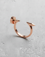 Rose gold plated silver nail ring showcasing its warm metallic hue and modern, minimalist design on a concrete background.