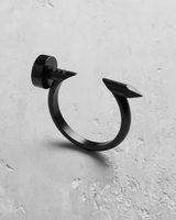 Silver nail ring with a matte black rhodium plating, showcasing the flat nail head and sharp tip on a white surface.
