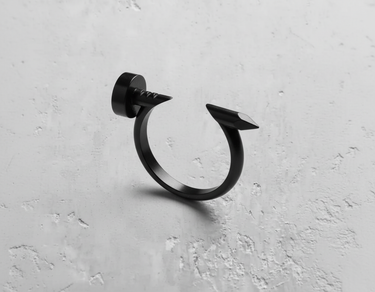 Silver nail ring with a matte black rhodium plating, showcasing the flat nail head and sharp tip on a white surface.