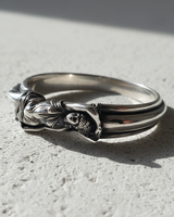 Silver Goddess Ring with a detailed reclining female figure, shown with an oxidized finish on a textured white surface.