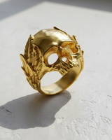 Angled view of the gold-plated Silver Laurel Skull Ring, highlighting the intricate wreath design and polished finish in sunlight.