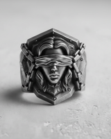 Front view of the Silver Blind Justice Ring, showcasing the blindfolded female face and chain details on a textured surface.