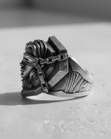 Side profile of the men's Silver Blind Justice Ring, detailing the sculpted hair and band on a light-colored, textured stone.