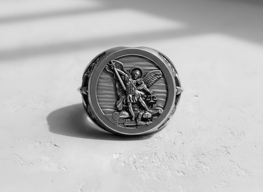 Front view of the silver Archangel Michael ring showing the saint slaying a demon with a sword and holding scales of justice.