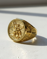 14K gold vermeil St Michael signet ring for men, showing the Archangel slaying a demon, angled on a white surface.
