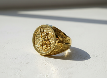14K gold vermeil St Michael signet ring for men, showing the Archangel slaying a demon, angled on a white surface.