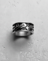Top-down view of the handcrafted music themed band ring, displaying the continuous pattern of instruments and notes.